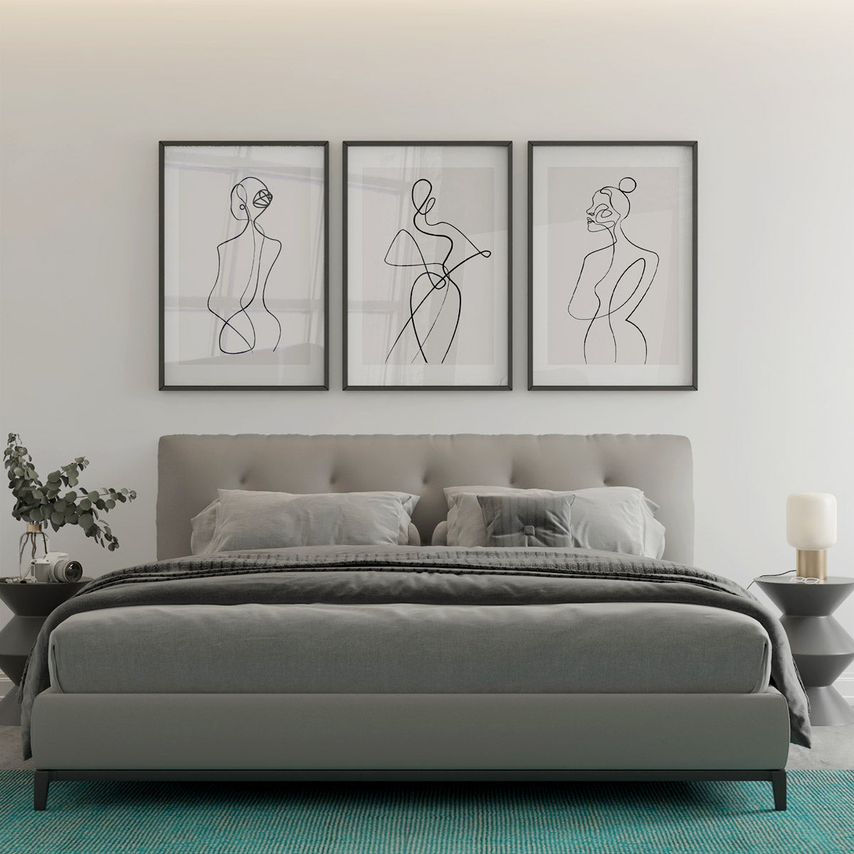 A set of 3 abstract line art prints hanging above a bed