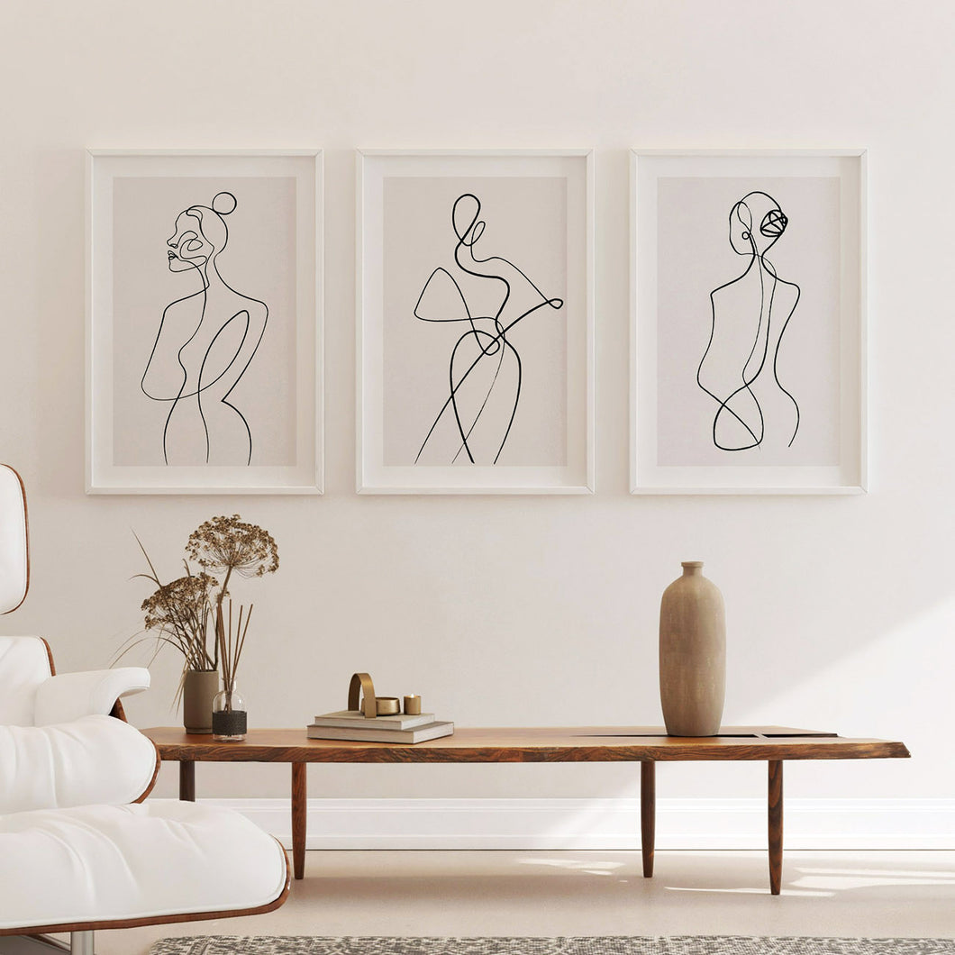 A set of 3 minimalist line art prints hanging in a study