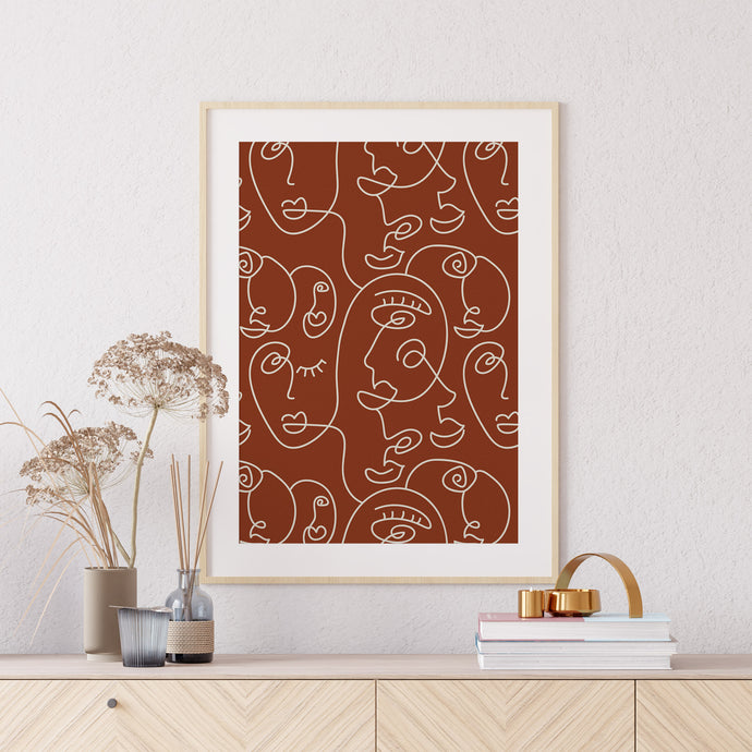 Terracotta wall art featuring abstract faces in a bohemian style
